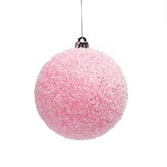 a pink ball ornament hanging from a string on a white background with clippings