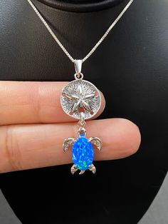 "Sterling Silver Sand Dollar and Turtle Charm Pendant Necklace Blue Opal Turtle Necklace Metal: All components are made from solid .925 Sterling Silver Measurement: pendant height is 44mm (1.7\") including bail and 16mm (0.63\") wide Choose Chain Length At Checkout You can find other charm jewelry in my shop here https://www.etsy.com/shop/LinksAndStones?ref=seller-platform-mcnav&section_id=24389019 Please feel free to Convo me with any questions before purchasing. Please view policy before p Ocean-inspired Blue Pendant Jewelry, Blue Pendant Jewelry For Beach, Ocean-inspired Blue Pendant Necklace, Blue Large Round Pendant Jewelry, Blue Round Large Pendant Jewelry, Ocean-inspired Blue Round Pendant Jewelry, Handmade Ocean Colored Pendant Jewelry, Handmade Ocean Color Pendant Jewelry, Ocean-inspired Nickel-free Blue Jewelry