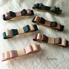 four different colored hair clips sitting on top of a white towel next to each other