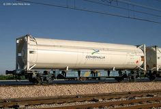 a train car sitting on the tracks next to some power lines