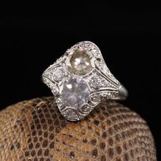 Beautiful Antique Art Deco Platinum Fancy Colored Diamond Filigree Two Stone Ring. This unbelievable band has two fancy colored diamonds in a pristine art deco mounting.Item #R0801Metal: PlatinumDiamonds: 1.17 ct Old Cut Fancy Grey and a 1.27 ct Old Cut Fancy Brownish Yellow. Clarity: VS2 - SI1Accent Diamonds: Approximately .50 ctsColor: HClarity: VS2Weight: 5.2 GramsRing Size: 5 1/2This ring can be sized for an additional $50Measurements: 17.9 mm widthMeasurement of the ring off the finger: 6.4 Art Deco Platinum Diamond Ring In Diamond White, Art Deco Three Stone Platinum Jewelry, Art Deco Three Stone Diamond White Ring, Diamond White Three Stone Art Deco Ring, White Brilliant Cut Filigree Ring In Art Deco Style, Art Deco White Filigree Ring With Brilliant Cut, White Filigree Ring In Brilliant Cut, Art Deco Style, Art Deco Platinum Diamond Ring With Rose Cut Diamonds, Antique White Diamond Platinum Ring