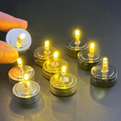 a person is holding some small candles in their hand