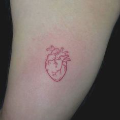 a small red heart tattoo on the arm