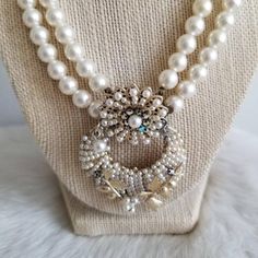 This is a vintage statement necklace from the 1950's-1960's. The necklace is made from two white pearl tone bead strands. The pendant is also the clasp of the necklace and is a white pearl tone and AB crystal statement piece. The back is a gold tone metal with the Japan signature. The necklace has a few areas of wear on the back from age. The necklace is in great condition.Measurements:Strand Length: 17" | Pendant Length: 2.25" | Pendant Width: 1.75"Unless otherwise stated all vintage items are Vintage Round Pearl Drop Necklace, Vintage Pearl White Round Necklaces, Vintage White Round Beaded Necklaces, Vintage Round Necklace With Pearl Charm, Vintage Pearl Necklace With Round Beads, Vintage Round Pearl Chain Necklace, Vintage Pearl Necklace With Pendant, Vintage Pearl White Necklace With Pearl Pendant, Vintage Cream Pearl Drop Necklace