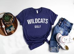 Show your school spirit with our Wildcats shirts, perfect for every sport and club! 🐾 Whether you're cheering from the sidelines, hitting the field, or representing your favorite club, these shirts are made for you! Customize with your sport or club name to make it uniquely yours. Go Wildcats! 🎉 Bella and Canvas Unisex TShirt #WildcatsPride #TeamSpirit #ClubLife #WildcatsNation #GoWildcats #SchoolSpirit #GameDayReady #SupportYourTeam #BootsandRootsApparel #Mompreneur #CustomWildcatsShirts #Pro Varsity T-shirt With Team Name For College, Sports Tops With University Logo For Sports Season, University Logo Sports Tops For Sports Season, University Logo T-shirt For Game Day, Sporty T-shirt With University Logo, College Football Season School Spirit T-shirt, Varsity Team-colored Screen Print T-shirt, Varsity Team-colored T-shirt With Screen Print, Varsity Style Team-colored Screen Print T-shirt