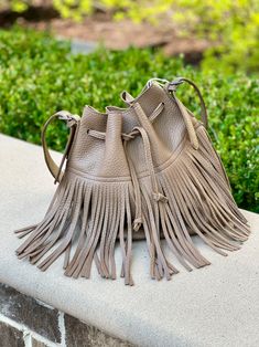 Introducing this trendy fringed bucket shoulder handbag, made from synthetic leather. It's perfect for your bohemian wardrobe! This taupe colored bag is not only aesthetically pleasing but also practical, making it an ideal purse for everyday use. Chic Brown Fringe Hobo Bag, Chic Beige Fringe Shoulder Bag, Chic Fringe Hobo Bag For Travel, Chic Travel Hobo Bag With Fringe, Chic Travel Bucket Bag With Fringe, Chic Beige Fringe Bag, Chic Fringe Shoulder Bag For Travel, Chic Brown Hobo Bag With Tassels, Chic Travel Shoulder Bag With Fringe