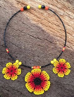 My flower choker is definitely for a Boho girl or lady, who has a love for bright and sunny colours and nature. What better way to add some sunshine to your life than with this lightweight piece?  Repurposed beaded flowers.  Repurposed wooden yellow beads. Repurposed black and orange plastic crystals. Repurposed small plastic orange and yellow beads. Repurposed black glass seed beads. New silver plated memory wire. New silver plated jump rings. Approximately 15.5cm long. Central flower approxima Multicolor Beaded Necklace With Flower Pendant, Colorful Choker, Charity Shop Finds, Flower Choker, Earrings Making, Boho Choker, Boho Girl, Gorgeous Flowers, Black And Orange