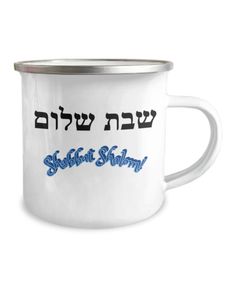 a white coffee mug with hebrew writing on the bottom and blue lettering in black ink