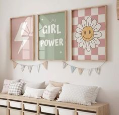 three framed pictures hang on the wall above a wooden bench with pillows and pillow cases