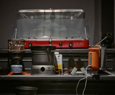 an assortment of cooking utensils are sitting on a shelf in front of a stove