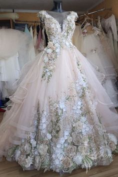 a dress made out of flowers on display in a room with other wedding gowns