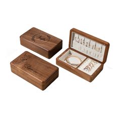 three wooden boxes with jewelry in them on a white background, one containing rings and the other containing bracelets