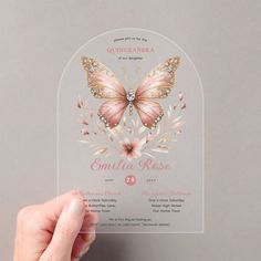 a person holding up a glass card with a butterfly on it's back and the words quincecianera written in pink