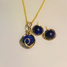 "Beautiful Natural Lapis Lazuli Necklace & Earrings Set In 14K Gold Filled Wire. This natural Lapis Lazuli has a fine, deep blue color with some Gold pyrite and calcite inclusions. The Lapis Lazuli Pendant has a 12 mm Round Stone Wire wrapped with 14K Gold Filled wire. The custom French Earring wires are 14K Gold Filled Wire wraping around 10 mm Lapis Lazuli Stones. Beautifully handmade and hammered in my Florida Studio. All 14k Gold Wire is Nickle free. These earrings come with soft silicon Sapphire Gemstone Jewelry Set As Gift, Sapphire Jewelry With Matching Earrings For Gift, Sapphire Jewelry Sets With Matching Earrings As Gift, Gold Lapis Lazuli Jewelry Set With Earrings, Gold Lapis Lazuli Jewelry Gift, Gold Lapis Lazuli Jewelry For Gift, Round Lapis Lazuli Jewelry For Gifts, Jewelry With Matching Round Beaded Earrings For Gifts, Jewelry With Matching Round Bead Earrings For Gifts