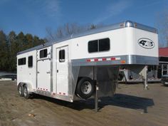 a white horse trailer parked in a parking lot