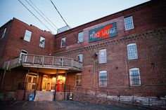 an old brick building with a sign on the front and stairs leading up to it