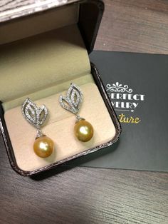 We are presenting you A PAIR OF matching SOUTH SEA PEARLS with LUSTROUS GOLDEN color. SET IN HANDCRAFTED, 18K SOLID GOLD DROP EARRINGS. ACCENTED WITH 116 E/VS, SPARKLING ROUND BRILLIANT DIAMONDS! IN CASE OF RETURN FOR US BUYERS. BUYERS MAY SEND THE ITEMS BACK TO OUR US-BASED OFFICE IN SALT LAKE CITY, UTAH ONLY ONE ITEM AVAILABLE!! NO DUPLICATES!! WHAT YOU SEE IN THE PICTURES IS WHAT YOU WILL GET SOLIDLY HANDCRAFTED EARRINGS! SUGGESTED RETAIL VALUE: $9,880 PEARLS: Size: 12 x 11 mm Shape: Oval/Rou Elegant Drop Earrings For Celebration, Luxury Drop Pearl Earrings For Formal Occasions, Luxury Drop Pearl Earrings For Formal Events, Luxury Pear-shaped Pearl Earrings, Luxury Pearl Drop Earrings For Anniversary, Luxury Drop Pearl Earrings For Anniversary, Luxury Teardrop Earrings For Celebration, Luxury Pear-shaped Pearl Earrings For Anniversary, Anniversary Luxury Drop Pearl Earrings