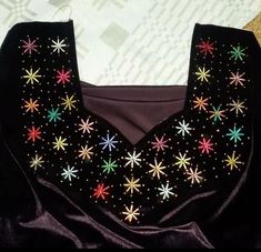 a black top with multicolored stars on it