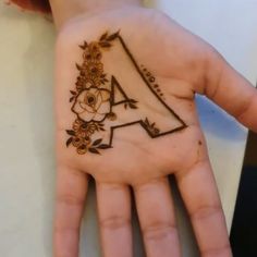 a person's hand with a flowered design on it and the letter a