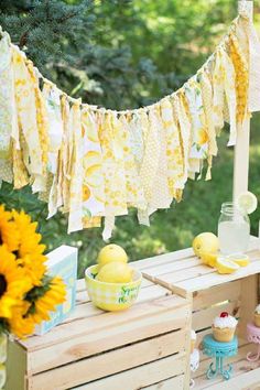 an outdoor picnic with lemons, cupcakes and bunting flags on the table