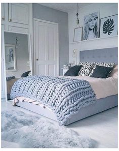 a bedroom with a bed, rugs and pictures on the wall above it's headboard