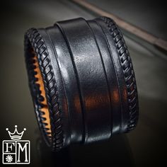 "This Black leather cuff is 2\" wide and hand dyed in a sleek black finish. It is hand braided along the edges with kangaroo lace and also features a hand tooled beveled ridge. A 3/4\" strap is woven through center and closes with leather covered snaps! Custom sized for your wrist! -2\" wide -Vegetable tanned leather -fully lined -Handmade in New York Thanks! Freddie" Handmade Black Cuff Bracelet, Black Handmade Cuff Bracelet For Formal Occasions, Formal Black Leather Braided Bracelets, Formal Black Handmade Cuff Bracelet, Formal Handmade Black Cuff Bracelet, Adjustable Leather Cuff Bracelet Hand-stitched, Handmade Black Leather Bracelets, Adjustable Hand-stitched Leather Cuff Bracelet, Handmade Black Leather Cuff Bracelet