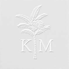 a white palm tree with the letter k m on it's front and bottom