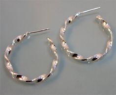 "These Spiral Twist earrings are fabricated from sheet sterling silver and handmade from start to finish. They are the perfect size hoop for everyday wear. 1\" diameter, apporx 3mm width and 1mm\" thick silver. Earrings also have a sterling silver post and back. For an alternative look, these can also be fabricated with a satin finish. All items are presented in a 100% recycled paper box with a paper raffia bow. Thank you for looking at my shop. http://www.etsy.com/shop/tinysparklestudio For LEA Spiral Sterling Silver Hoop Earrings, Silver Spiral Hoop Earrings For Everyday, Everyday Silver Spiral Hoop Earrings, Everyday Spiral Silver Hoop Earrings, Twist Earrings, Recycled Sterling Silver, Paper Box, Recycled Paper, Open Back