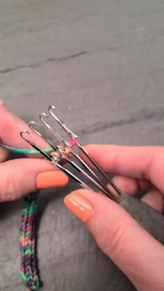 a woman is holding several pairs of scissors in one hand and some knitting needles in the other