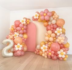 balloons are arranged in the shape of a house and number two, as well as flowers