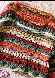 a crocheted blanket sitting on top of a bed