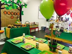 a green table topped with plates and balloons