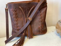 Brown Tassel Shoulder Bag For Everyday, Everyday Brown Shoulder Bag With Tassels, Leather Travel Bag With Tassels, Leather Hobo Bag With Tassels For Everyday, Brown Tassel Bags For Daily Use, Leather Shoulder Bag With Tassels For Travel, Leather Satchel With Tassels, Leather Satchel With Tassels For Travel, Leather Satchel Shoulder Bag With Tassels