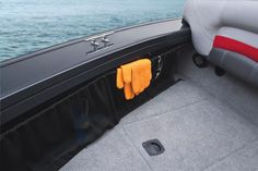 the inside of a boat with two gloves hanging on it's armrests