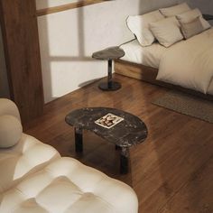 a living room filled with furniture and a bed next to a wooden floor covered in pillows