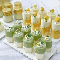 there are many small desserts on the table with white and yellow flowers in them