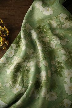 a close up of a cloth with flowers on it next to a dried flower head