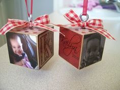 two small cubes with pictures on them are hanging from red and white ribbon ties