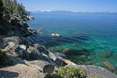 the water is crystal blue and clear at this rocky shore line in lake tahoe