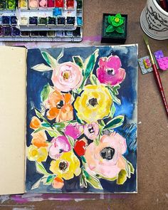 an art journal with watercolors and flowers on it next to paintbrushes