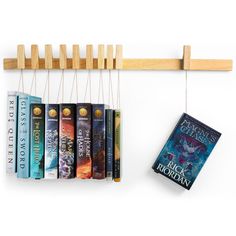 a book rack with books hanging from it's sides next to a row of books