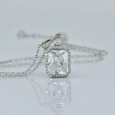 "Classically elegant and sophisticated! Emilia cz crystal bridal necklace made in a radiant cut with a frame of tiny cz crystals for a beautiful sparkling accessory that will suit your dress, whatever style. The 18K rhodium setting has delicate carving around the sides so your necklace is pretty from all aspects! All components are rhodium plated sterling silver. Nickel free. Rhodium plating helps prevent issues with silver allergies. Measurements: Chain - With extender measures 16\" - 18\" (41 Luxury Square Pendant Solitaire Necklace For Gift, Elegant Cubic Zirconia Solitaire Necklace With Square Pendant, Wedding Solitaire Necklace With Square Pendant, Emerald Cut Cubic Zirconia Solitaire Necklace For Wedding, Elegant Baguette Cut Solitaire Necklace For Wedding, Elegant Emerald Cut Solitaire Necklace For Wedding, Elegant Emerald Cut Diamond Necklace For Wedding, Elegant Diamond White Rectangular Necklace, Elegant Rectangular Diamond White Necklace