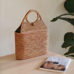 The Bali Tall Malboro Rattan Straw Handbag is the perfect accessory for any stylish woman. This beautiful, handmade rattan bag is made by skilled artisans in Bali, using natural materials to create a one-of-a-kind piece that is both fashionable and functional. The tall, cylindrical shape adds a unique touch to the classic rattan style, making it the perfect bag for everyday use or a night out. With its spacious interior and beautiful design, the Tall Malboro Rattan Handbag is sure to impress. Sh Eco-friendly Palm Leaf Bag With Open Weave, Natural Woven Leather Top Handle Bag, Traditional Natural Color Top Handle Shoulder Bag, Traditional Natural Top Handle Shoulder Bag, Traditional Top Handle Shoulder Bag In Natural Color, Bohemian Crochet Bag With Woven Leather, Bohemian Rectangular Crochet Bag With Woven Leather, Bohemian Crochet Bag With Woven Leather In Rectangular Shape, Traditional Rectangular Bags With Bamboo Handle