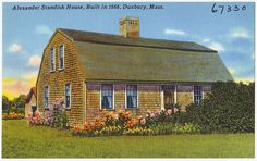 an old postcard shows a small wooden house with flowers in the front and side