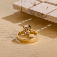 two gold rings sitting on top of a wooden table