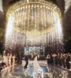 a newly married couple is surrounded by confetti and sparkles at the end of their wedding ceremony