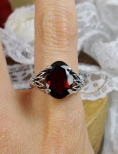 Natural Garnet Ring Tiki Design#122 Custom Made This is a brand new stunning Art Nouveau and Gothic-inspired sterling silver filigree ring. The VS to VVS oval full cut high quality genuine natural garnet is 14mm (9/16th of an inch) by 10mm (3/8 inch) in dimension... The natural 6.5ct to 7ct garnet has a lovely deep red, Merlot color, simply stunning! The inside of the band is marked 925 for sterling. Notice the beautiful filigree swirl like craftsmanship of the silver setting. This is an exquisi Elegant Oval Ruby Ring For Gift, Oval Ruby Ring In White Gold For Gift, Oval Red Garnet Jewelry, Exquisite Silver Oval Ruby Ring, Sterling Silver Ruby Ring Oval Cabochon For Formal Events, Sterling Silver Ruby Ring, Oval Cabochon For Formal Events, Formal Sterling Silver Ruby Ring With Oval Cabochon, Elegant Jewelry With Oval Cabochon Garnet, Oval Garnet Ring Hallmarked