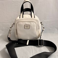 Nwt. It Can Be Carried With Top Handles Or Crossbody With Adjustable Strap. Logo In Front On Zip Pocket . Approximate Measurement: 7”H X 7”W X 4”D Strap Length: 54” Strap Drop: 25” Handle Length: 10” Handle Drop: 4” White Satchel Shoulder Bag With Zipper Closure, White Crossbody Bag With Zipper Closure, White Everyday Mobile Phone Bag, Everyday White Mobile Phone Bag, Casual White Shoulder Bag For On-the-go, White Shoulder Bag With Mobile Phone Pocket For Errands, White Double Handle Shoulder Bag With Phone Pocket, White Backpack With Mobile Phone Bag, Trendy White Shoulder Bag For Travel