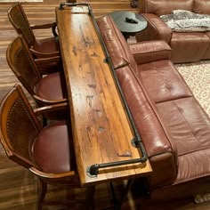 a table with chairs and a couch in the middle of it on a hard wood floor