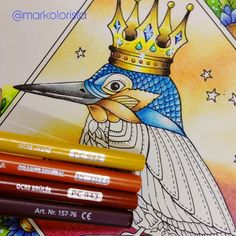 some colored pencils sitting on top of each other next to an image of a bird wearing a crown